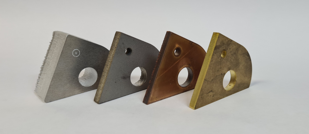 Laserschneiden: Teststücke aus Aluminium, Titan Kufper und Messing.